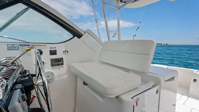 Slide: The Image of Helm Station with Seating This image showcases the helm station of the 2007 Tiara Yachts 32 Open, featuring a sleek and modern design. The helm is equipped with a comfortable, cushioned bench seat, perfect for navigating in comfort. The area offers expansive views, ensuring excell - 6394600