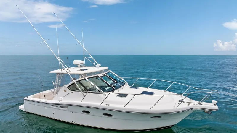 Slide: The Image of Starboard Side View of Tiara 32 Open This image showcases the sleek starboard side of the 2007 Tiara 32 Open, highlighting its elegant lines and spacious cockpit. The vessel is equipped with robust fishing rods and a hardtop that provides shade and protection. Its clean, white hull and expan - 6394606
