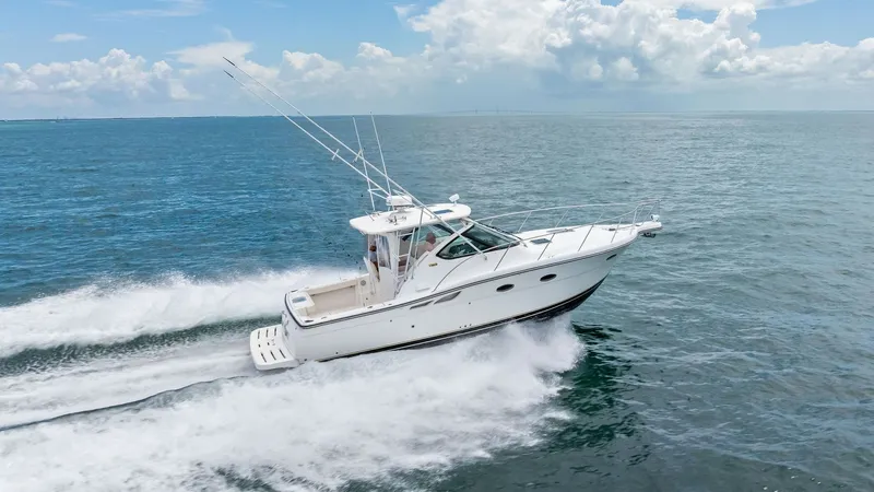 Slide: The Image of Starboard Aerial View in Motion This dynamic aerial shot captures the 2007 Tiara 32 Open 'Second Chance' slicing through open waters. The vessel's sleek profile is accentuated by its elegant white hull and spacious aft deck, perfect for fishing or leisure. The powerful twin engines crea - 6394609