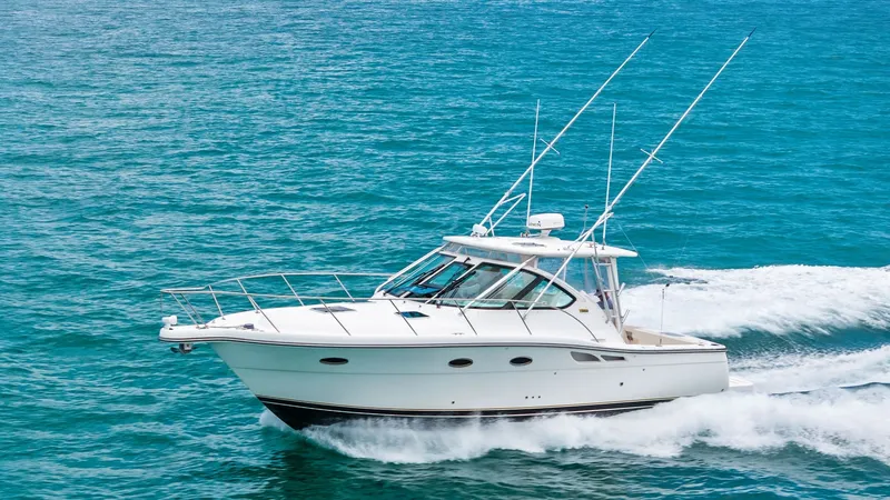 Slide: The Image of Tiara 32 Open Cruising Profile The 2007 Tiara 32 Open, 'Second Chance', glides effortlessly across the water, showcasing its sleek hull and elegant lines. The vessel features a sturdy hardtop with rod holders and an expansive windshield, offering excellent visibility for navigation. It - 6394617