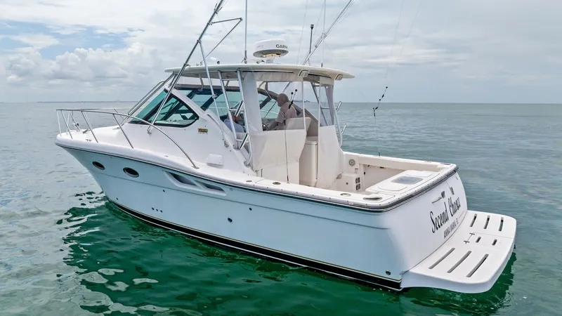 Slide: The Image of Aft Deck and Swim Platform View This image showcases the sleek aft deck and swim platform of the 2007 Tiara Yachts 32 Open, named 'Second Chance'. The ample cockpit space is ideal for fishing or relaxing, featuring rod holders and a comfortable seating area. The swim platform provides e - 6394619