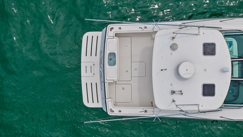 Slide: The Image of Aerial View of Aft Deck and Cockpit This overhead view showcases the spacious aft deck and cockpit of the 2007 Tiara Yachts 32 Open. The clean layout is designed for both functionality and leisure, featuring ample seating and storage compartments. The swim platform extends the outdoor livin - 6394621