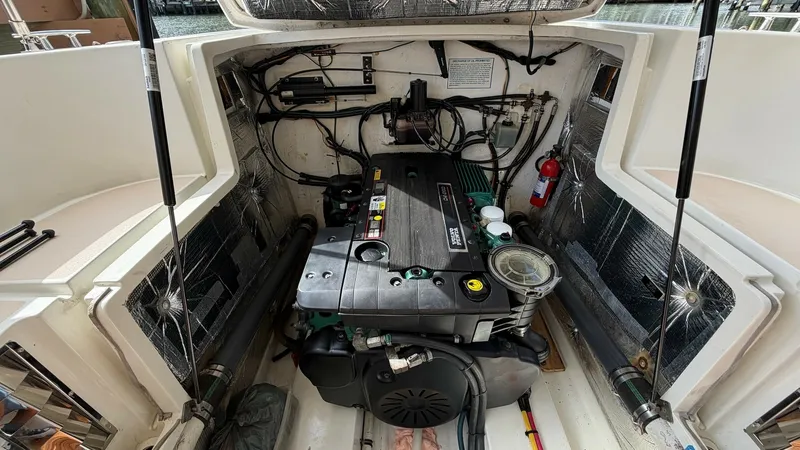 Slide: The Image of Engine Compartment with Volvo Penta Engine This image showcases the meticulously maintained engine compartment of the 2008 MJM Yachts 29z, featuring a powerful Volvo Penta engine. The compartment is well-organized, with sound-dampening insulation lining the walls for a quieter ride. Essential comp - 6479425