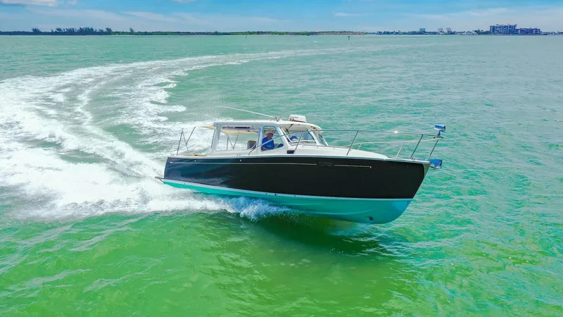 Slide: The Image of Aerial View of Camelot at Sea The 2008 MJM Yachts 29z, Camelot, is captured gliding effortlessly over the vibrant blue-green waters. Its sleek hull design and elegant lines highlight the yacht's superior craftsmanship and agility. With clear skies above, the vessel showcases its power - 6479435