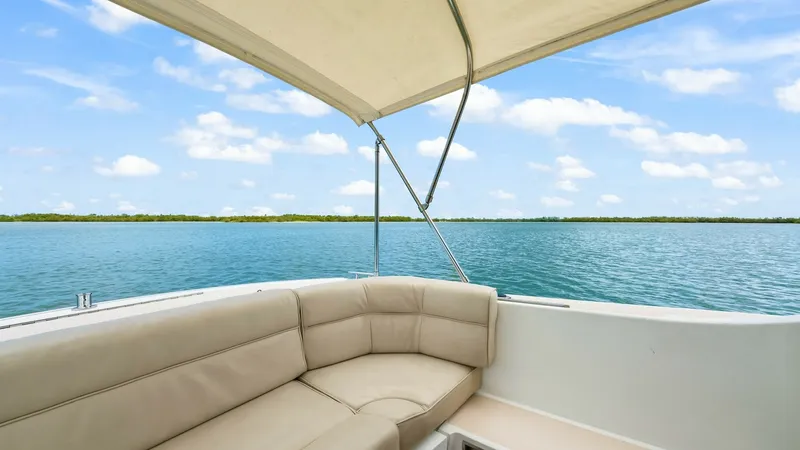 Slide: The Image of Aft Deck Seating with Canopy This inviting aft deck of the 2008 MJM Yachts 29z features plush, wrap-around seating perfect for socializing or relaxing. The beige upholstery complements the serene backdrop of open waters, while the overhead canopy provides shade and comfort. Ideal for - 6479408