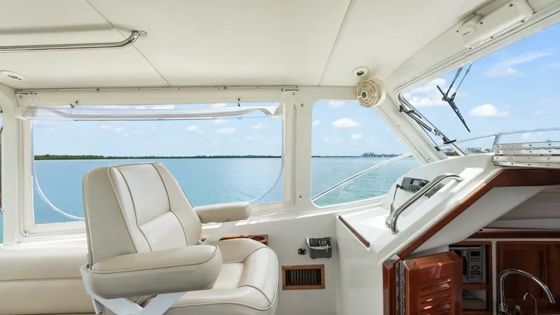 Slide: The Image of Helm Station with Panoramic Views This helm station on the 2008 MJM Yachts 29z offers a commanding view with its expansive windows, allowing for panoramic vistas of the sea. The ergonomic captain's chair provides comfort and support, while the polished wood accents add a touch of elegance - 6479391