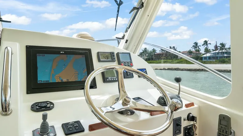 Slide: The Image of Helm Station with Navigation Display The helm station of the 2008 MJM Yachts 29z, Camelot, features a sleek stainless steel steering wheel and a modern navigation display for precise control. The layout includes intuitive controls and a clear view, enhancing the boating experience. The surro - 6479386