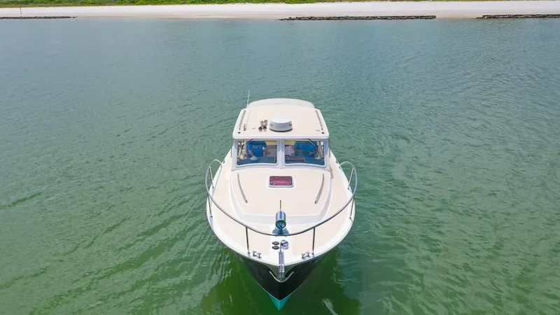 Slide: The Image of Bow View of MJM 29z Camelot This image captures the sleek bow of the 2008 MJM 29z Camelot gracefully cutting through calm waters. The vessel's classic lines are accentuated by its pristine white finish and robust stainless steel railings. The spacious foredeck and panoramic windshie - 6479373