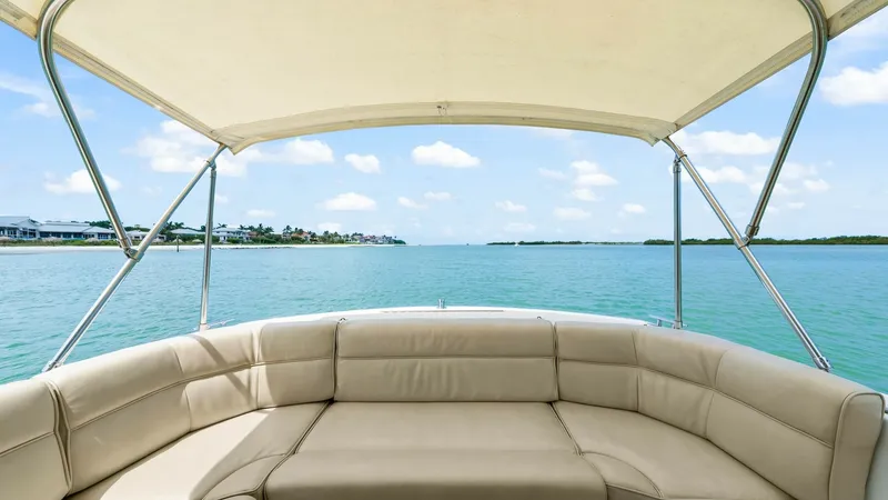 Slide: The Image of Spacious Aft Deck Seating Area This inviting aft deck on the MJM Yachts 29z Camelot offers ample seating with elegant beige upholstery. The area is shaded by a sturdy bimini top, providing comfort while enjoying panoramic views of the water. Ideal for relaxation or social gatherings, t - 6479404