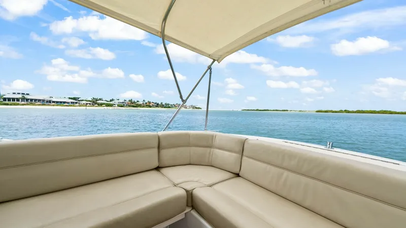 Slide: The Image of Spacious Aft Deck Seating The aft deck of the 2008 MJM Yachts 29z features plush, wraparound seating ideal for relaxation and entertaining. The neutral-toned upholstery complements the serene waterscape, offering a comfortable and inviting space. A sturdy canopy provides ample sha - 6479409