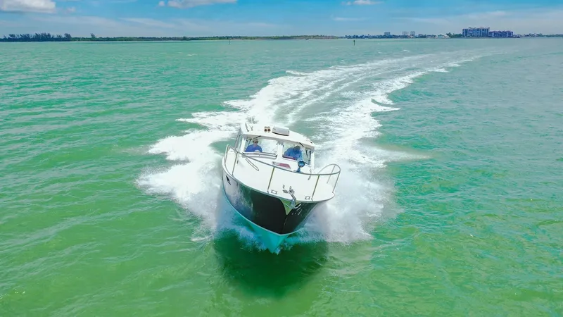 Slide: The Image of Dynamic Bow View on Open Water The 2008 MJM Yachts 29z, Camelot, cuts through the vibrant green waters with grace. Its sleek bow design and efficient hull shape are designed for smooth cruising and excellent performance. The vessel's elegant lines and robust construction make it ideal - 6479437