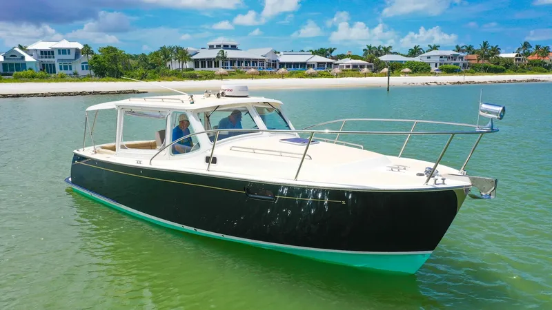 Slide: The Image of Starboard Side View of MJM 29z The MJM 29z 'Camelot' boasts sleek lines and a classic profile, with a sophisticated dark hull contrasting the bright, open deck. The vessel's design allows for excellent visibility and smooth cruising, ideal for coastal exploration. Its elegant structure - 6479374