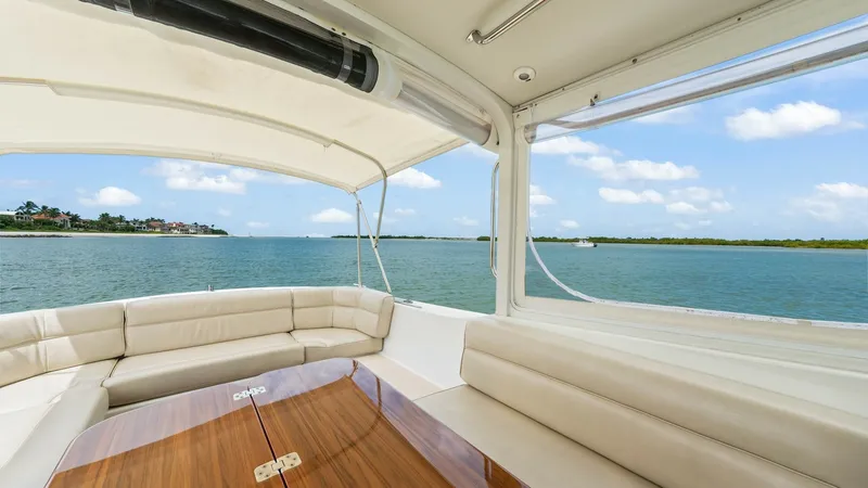 Slide: The Image of Spacious Aft Deck Seating Area The aft deck of the 2008 MJM Yachts 29z 'Camelot' features an inviting seating area with plush, cream-colored cushions. The elegant wooden table serves as a centerpiece, perfect for entertaining guests while enjoying panoramic views. Large windows and a r - 6479401