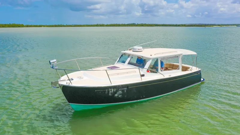 Slide: The Image of Elegant Exterior View of Camelot This image showcases the sleek exterior of the 2008 MJM Yachts 29z model, Camelot. The vessel's sophisticated design features a spacious cockpit with ample seating, perfect for leisurely cruising. Its elegant lines and classic color scheme enhance its tim - 6479377