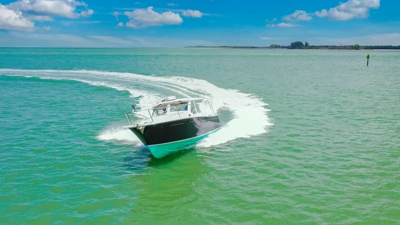 Slide: The Image of Dynamic Bow View Underway The MJM 29z Camelot from 2008 is captured gracefully cutting through the water, showcasing its sleek hull design. The vessel's clean lines and elegant profile are emphasized as it navigates with ease, creating a striking contrast against the vibrant blue - 6479441