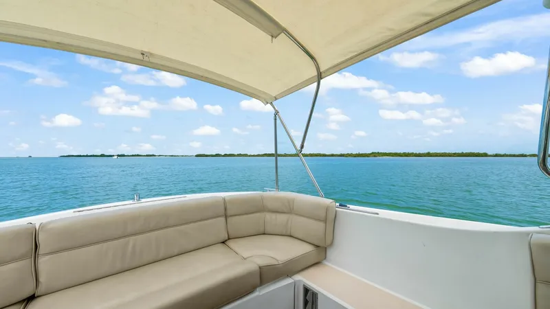 Slide: The Image of Spacious Aft Deck with Bimini Shade This inviting aft deck on the 2008 MJM Yachts 29z Camelot offers ample seating with plush, beige cushions ideal for relaxation and socializing. The area is sheltered by a Bimini top, providing shade and comfort while cruising. Enjoy panoramic views of the - 6479403