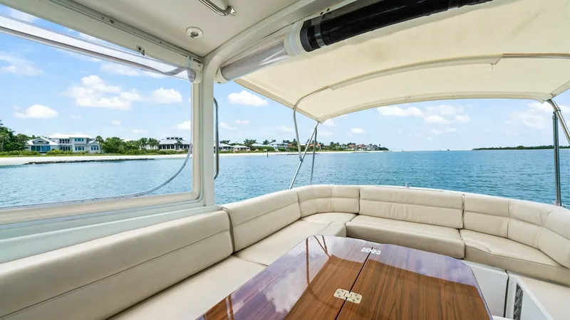 Slide: The Image of Spacious Aft Deck with Seating The aft deck of the 2008 MJM Yachts 29z features a luxurious wrap-around seating area with plush cushions, providing ample comfort for guests. The elegant wooden table at the center is perfect for entertaining or enjoying a meal with a view. The retractab - 6479402