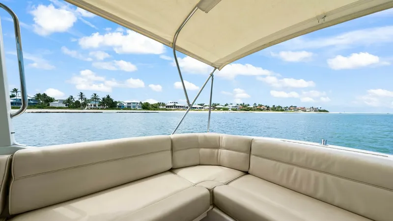Slide: The Image of Aft Deck with Seating Area This inviting aft deck features a comfortable U-shaped seating area, perfect for relaxing and enjoying panoramic ocean views. The plush, cream-colored cushions provide a luxurious feel, while the overhead canopy offers shade for a pleasant cruising experi - 6479405
