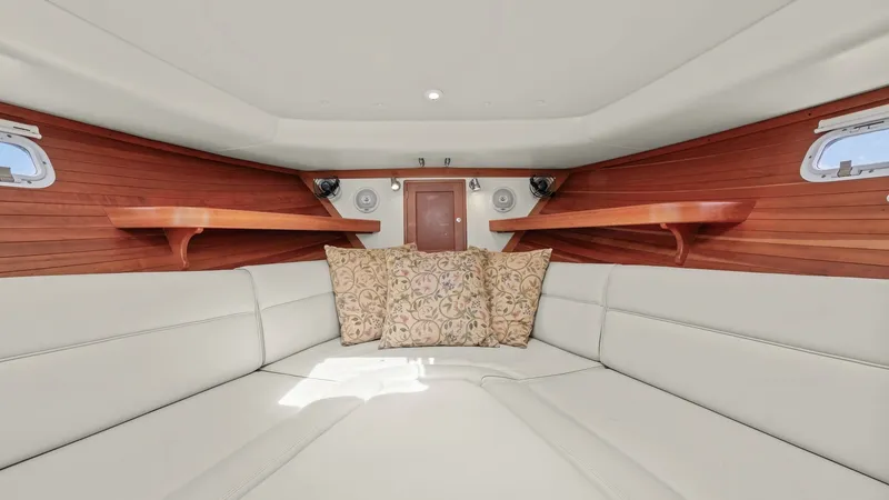 Slide: The Image of Spacious Forward V-Berth Cabin The forward V-berth cabin of the 2008 MJM Yachts 29z features elegant wood paneling and plush, cream-colored seating, creating a warm and inviting atmosphere. Custom shelving and soft accent lighting enhance the cozy space, while dual portholes provide na - 6479419