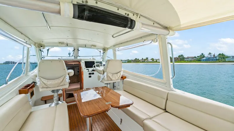 Slide: The Image of Spacious Cockpit with Helm Seating The cockpit of the 2008 MJM Yachts 29z 'Camelot' offers an inviting space with plush, wrap-around seating and a polished wooden table, perfect for socializing or dining. The helm area features two comfortable captain's chairs and modern navigational contr - 6479393