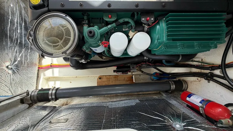 Slide: The Image of Engine Compartment with Volvo Penta D4-260 This image showcases the engine compartment of the Camelot, featuring a robust Volvo Penta D4-260 engine. The area is well-organized, with visible wiring and a fire extinguisher for safety. The compartment's reflective insulation enhances light distributi - 6479429
