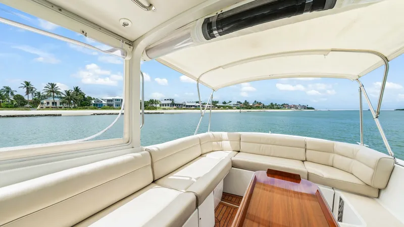 Slide: The Image of Spacious Aft Deck with Seating The Camelot's aft deck offers a luxurious and spacious seating area, perfect for entertaining guests while enjoying scenic views. The plush, wrap-around seating is complemented by a sleek wooden table, providing an ideal setting for relaxation or dining. - 6479397