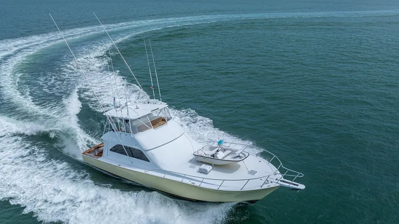 Slide: The Image of Aerial View of Viking 61 Convertible This dynamic aerial shot showcases the sleek profile of the 2002 Viking 61 Convertible, 'Bolita Too', cutting through the ocean. The vessel's spacious flybridge and well-appointed cockpit are designed for optimal sportfishing and leisure. Its classic line - 6683684