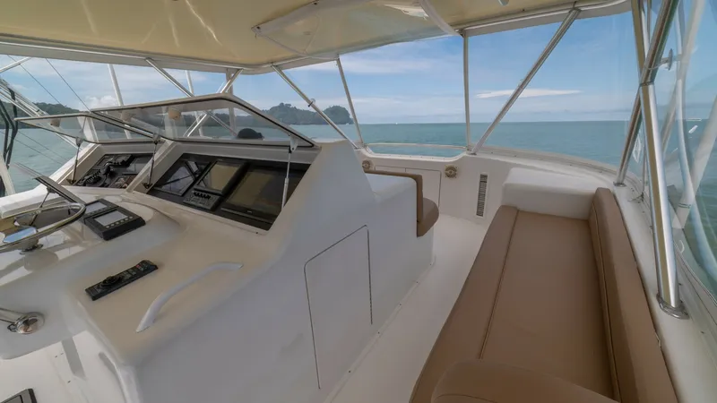 Slide: The Image of Flybridge Helm with Seating 2002 Viking 61 Convertible This image showcases the flybridge helm of the 2002 Viking 61 Convertible, featuring a sleek console equipped with state-of-the-art navigation technology. The spacious seating area offers comfort with its plush cushions and panoramic ocean views, making i - 6683666
