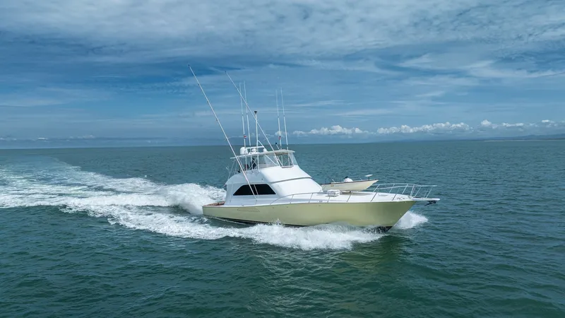 Slide: The Image of 2002 Viking 61 Convertible at Sea This image showcases the sleek profile of the 2002 Viking 61 Convertible, cutting through the water with grace and power. The boat's aerodynamic lines and robust construction are evident, designed for both sportfishing and luxury cruising. The flybridge o - 6683693