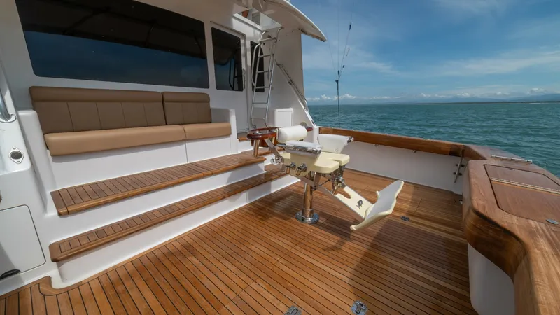 Slide: The Image of Teak Cockpit with Seating 2002 Viking 61 Convertible This inviting cockpit on the 2002 Viking 61 Convertible features elegant teak flooring and comfortable bench seating, ideal for relaxation or social gatherings. The fishing chair is perfectly positioned for angling enthusiasts, while the surrounding open - 6683644
