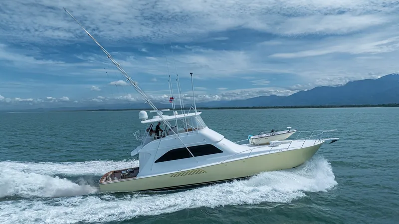 Slide: The Image of Side Profile of 2002 Viking 61 Convertible This image captures the sleek side profile of the 2002 Viking 61 Convertible, 'Bolita Too,' slicing through the water. The vessel showcases its distinctive, elegant lines and robust build, characteristic of Viking's craftsmanship. The flybridge and spacio - 6683690