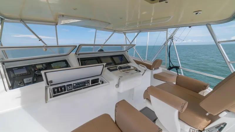 Slide: The Image of Flybridge Helm with Seating 2002 Viking 61 Convertible The flybridge of the 2002 Viking 61 Convertible, Bolita Too, features a well-equipped helm station with advanced navigation systems. The area is complemented by comfortable, cushioned seating, offering a commanding view of the open sea. The spacious and f - 6683661