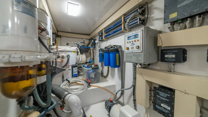Slide: The Image of Engine Room with Systems Overview 2002 Viking 61 Convertible The engine room of the 2002 Viking 61 Convertible showcases a well-organized layout featuring essential mechanical and electrical systems. Visible are advanced filtration units, control panels, and wiring, all meticulously arranged for optimal functionali - 6683660