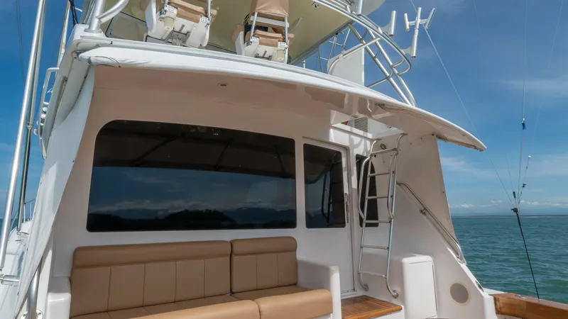 Slide: The Image of Cockpit Seating Area 2002 Viking 61 Convertible This image captures the flybridge and cockpit area of the 2002 Viking 61 Convertible, Bolita Too. The spacious cockpit features plush tan seating, perfect for entertaining or relaxing while enjoying ocean views. Above, the flybridge provides excellent vis - 6683651