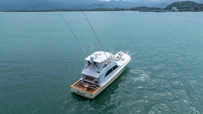 Slide: The Image of Aerial View of Aft Deck and Flybridge 2002 Viking 61 Convertible This aerial view showcases the expansive aft deck and flybridge of the 2002 Viking 61 Convertible, 'Bolita Too'. The aft deck is equipped for sportfishing, featuring rod holders and ample seating. The flybridge offers excellent visibility and is perfect f - 6683679