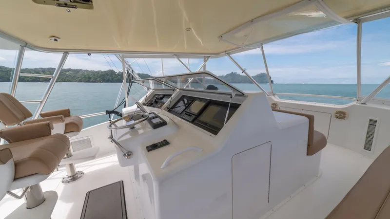 Slide: The Image of Flybridge Helm Station 2002 Viking 61 Convertible The flybridge helm station of the 2002 Viking 61 Convertible features an expansive view with dual captain's chairs offering comfort and style. The helm is equipped with advanced navigation systems and sleek controls for efficient vessel operation. The sur - 6683665