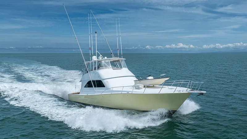Slide: The Image of Bow View in Open Water 2002 Viking 61 Convertible The Viking 61 Convertible 'Bolita Too' is showcased gracefully cutting through open water. Its sleek, powerful design features a prominently flared bow and a spacious foredeck. The vessel's sportfishing capabilities are highlighted by the numerous outrigg - 6683691