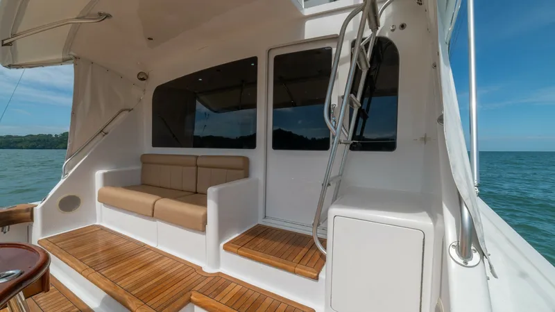 Slide: The Image of Cockpit with Seating Area 2002 Viking 61 Convertible The aft deck of the 2002 Viking 61 Convertible features elegant teak steps leading to a comfortable seating area. The space is designed for relaxation and socializing, with a plush bench seat and easy access to the main cabin. Large windows provide ample - 6683649