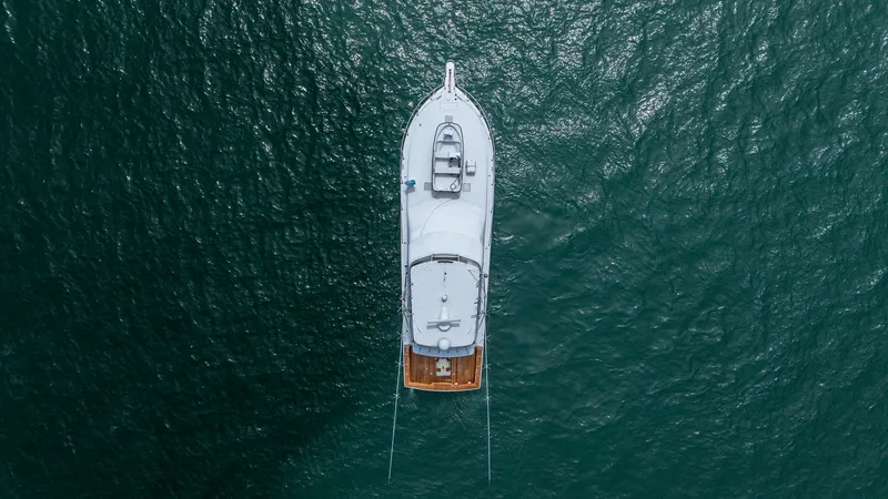 Slide: The Image of Aerial View of 2002 Viking 61 Convertible This aerial image showcases the sleek and balanced design of the 2002 Viking 61 Convertible, 'Bolita Too'. The vessel's spacious aft deck is visible, offering ample space for fishing or leisure activities. The flybridge and foredeck are also prominently f - 6683699