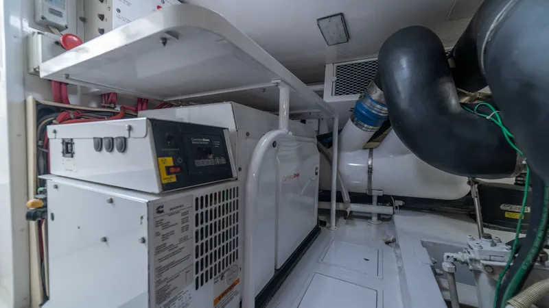 Slide: The Image of Engine Room with Generator 2002 Viking 61 Convertible The engine room of the 2002 Viking 61 Convertible showcases a well-maintained generator, essential for long voyages. The space is efficiently organized, with easy access to controls and essential equipment. The clean layout and high-quality materials ensu - 6683655
