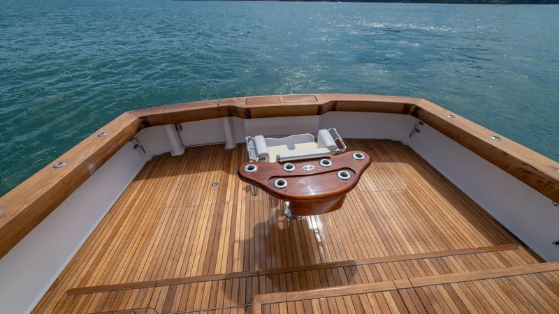 Slide: The Image of Spacious Teak Cockpit with Fighting Chair 2002 Viking 61 Convertible This elegant cockpit features finely crafted teak decking and a robust fighting chair, ideal for sportfishing enthusiasts. The spacious layout offers ample room for movement, with polished wood finishes enhancing the luxurious ambiance. Enjoy stunning vie - 6683652