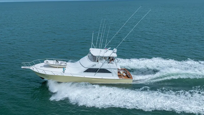 Slide: The Image of Viking 61 Convertible at Sea The 2002 Viking 61 Convertible, Bolita Too, is shown cruising effortlessly through open waters. Its sleek design features a spacious flybridge with multiple fishing rod holders, ideal for sportfishing enthusiasts. The vessel's robust hull and powerful eng - 6683686
