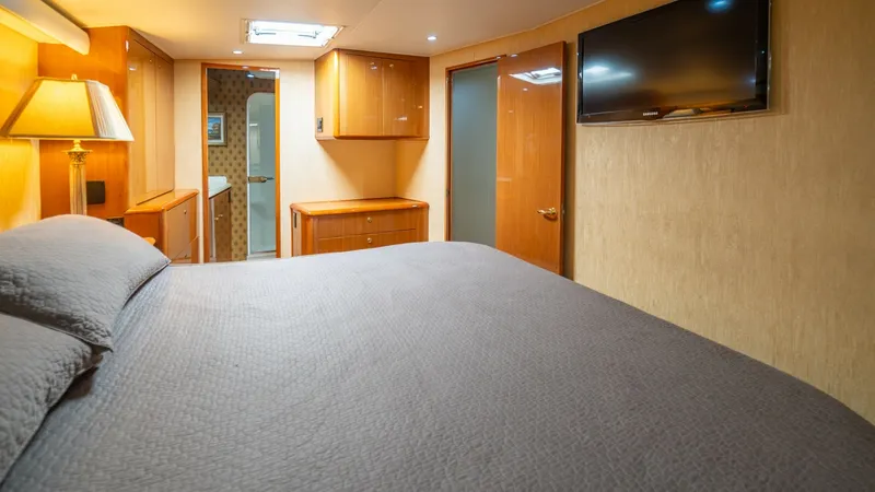 Slide: The Image of Master Stateroom 2002 Viking 61 Convertible The master stateroom of the Bolita Too exudes comfort and elegance with its spacious layout and refined finishes. A large, plush bed is complemented by warm wood cabinetry and ambient lighting, creating a serene retreat. Modern amenities include a wall-mo - 6683630