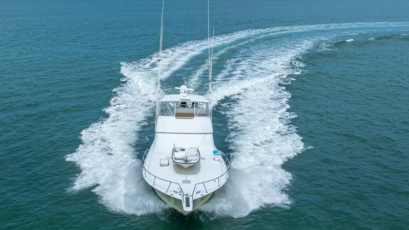 Slide: The Image of Bow View Cruising at Sea This image captures the sleek bow of the 2002 Viking 61 Convertible, 'Bolita Too,' gracefully cutting through the water. The vessel showcases its powerful performance with a clear wake, emphasizing its speed and agility. The spacious foredeck provides a p - 6683685