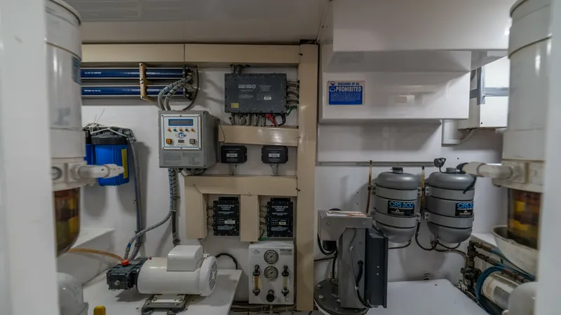 Slide: The Image of Engine Room with Equipment Panel 2002 Viking 61 Convertible The engine room of the 2002 Viking 61 Convertible, Bolita Too, showcases a well-organized equipment panel. The space features advanced control systems and filtration units, ensuring optimal performance and maintenance efficiency. The layout is designed fo - 6683658