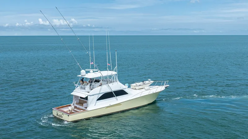Slide: The Image of Aerial View of 2002 Viking 61 Convertible This image showcases the sleek profile of the 2002 Viking 61 Convertible, 'Bolita Too,' cruising through open waters. The vessel's elegant lines and spacious flybridge are highlighted, providing an ideal vantage point for commanding views. The expansive a - 6683681
