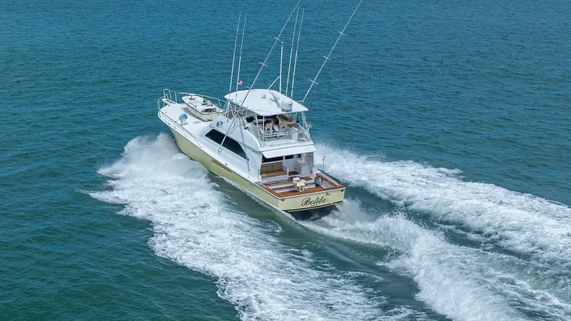 Slide: The Image of Aerial View of Aft Deck in Motion 2002 Viking 61 Convertible This dynamic aerial shot showcases the Bolita Too, a 2002 Viking 61 Convertible, navigating the open waters with grace. The aft deck is clearly visible, offering a spacious area for fishing or relaxation, complemented by elegant teak finishes. The vessel' - 6683682