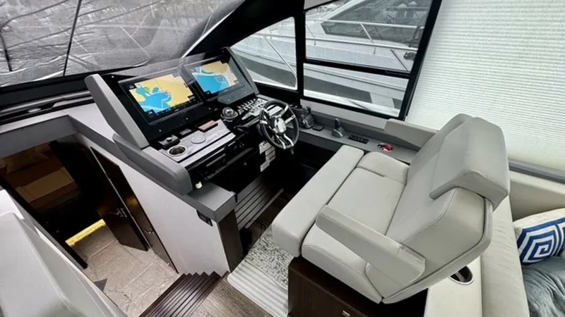 Slide: The Image of Helm Station with Dual Displays The helm station of the 2023 Cruisers Yachts 50 Cantius features dual navigation displays for precise control and navigation. The ergonomic captain's chair offers comfort and ease of access to all controls, ensuring an optimal piloting experience. Large w - 6489147