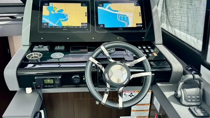 Slide: The Image of Helm with Dual Navigation Screens The helm of the 2023 Cruisers Yachts 50 Cantius boasts dual high-definition navigation screens, offering clear and precise chart plotting. The sleek steering wheel complements the modern, sophisticated dashboard, which includes essential controls and comm - 6489146