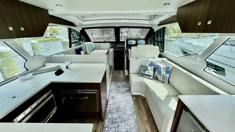 Slide: The Image of Spacious Interior Salon with Seating This elegant interior salon of the 2023 Cruisers Yachts 50 Cantius features sleek, modern design with luxurious seating arrangements. Large windows allow for panoramic views and ample natural light, creating a bright and inviting atmosphere. The high-qual - 6489144